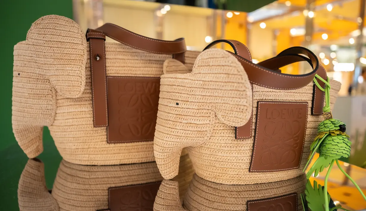 Ingin mencari tas yang unik dan menggemaskan? Elephant basket bag in raffia and calfskin wajib jadi pilihan. Elephant Basket adalah tas hybrid yang dibuat dari bahan rafia yang memadukan siluet khas tas keranjang LOEWE dengan kepala gajah. Versi medium ini dibuat di Spanyol menggunakan daun rafia yang telah dibudidayakan, dipanen, dijemur, dan ditenun dengan tangan oleh pengrajin di Madagaskar.  [ Foto dok LOEWE ]