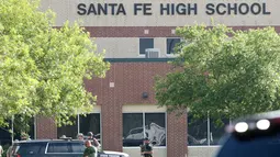 Aparat keamanan berlarian saat berusaha membekuk pelaku penembakan di Santa Fe High School, Texas, Amerika Serikat, Jumat (18/5). Aparat kepolisian menyebut mayoritas korban jiwa adalah para murid. (Steve Gonzales/Houston Chronicle via AP)