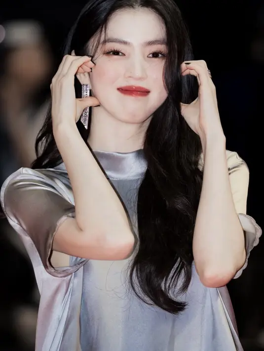 Han So Hee tampil dengan setelan flowy warna silver dari atasan tertutup lengan pendek kerah tinggi dan rok panjang. Dipadukan anting-anting silver panjang.  [@armanfebryan]