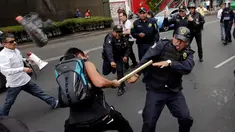 Seorang demonstran memukul polisi dengan kayu saat bentrokan terjadi memprotes penentangan adu banteng di luar arena adu banteng di Mexico City, Meksiko 29 Mei 2016. (REUTERS / Henry Romero)