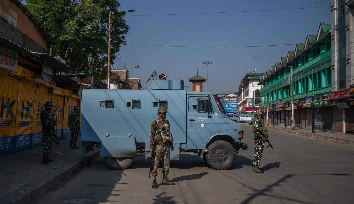 Paramiliter bersenjata bersiaga di jalan yang dikosongkan di Srinagar, Kashmir yang dikuasai India, Rabu (5/8/2020). Pasukan dan barikade kawat berduri dikerahkan oleh India dalam upaya menahan serangan pada peringatan setahun pelepasan status otonomi khusus wilayah tersebut. (AP Photo/ Dar Yasin)