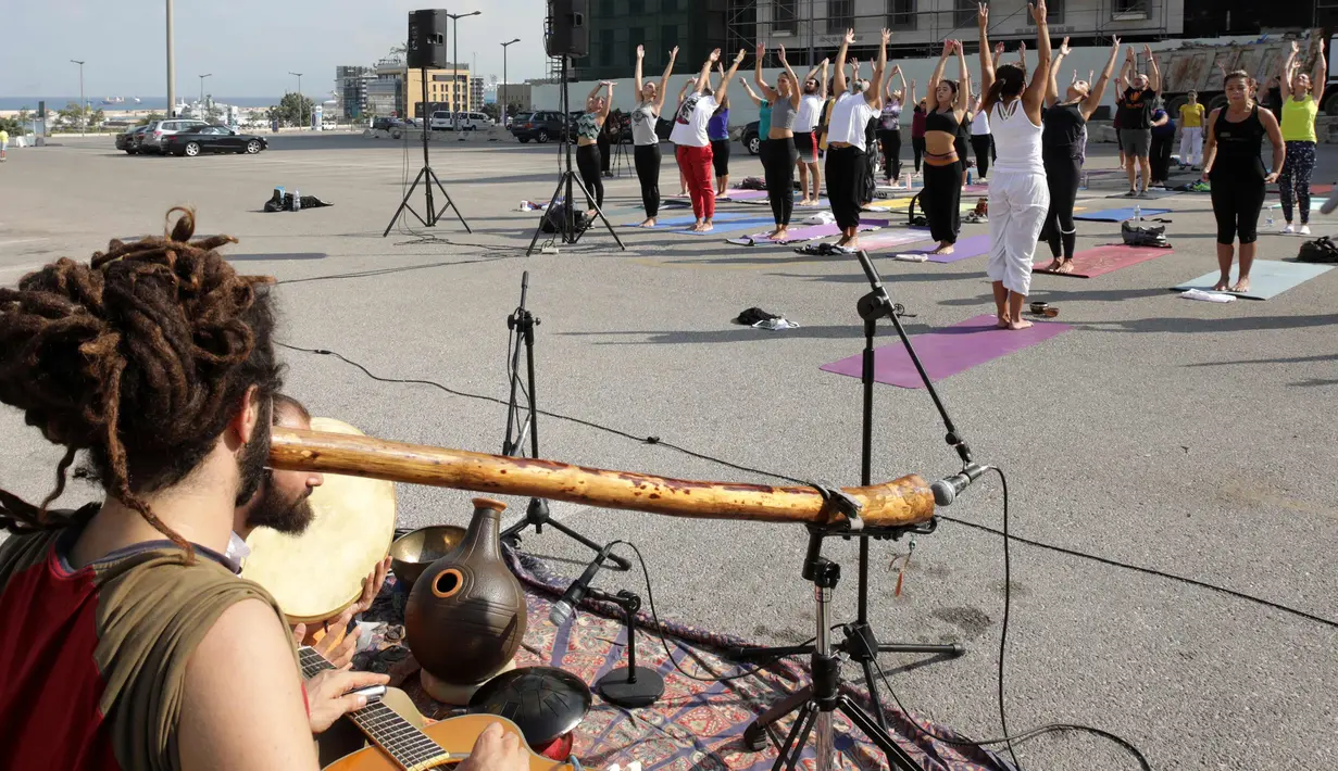 Warga Lebanon mengikuti instruktur melakukan gerakan yoga selama acara "108 Sun Salutations" di ibukota Martir Beirut (22/10). (AFP Photo/Anwar Amro)