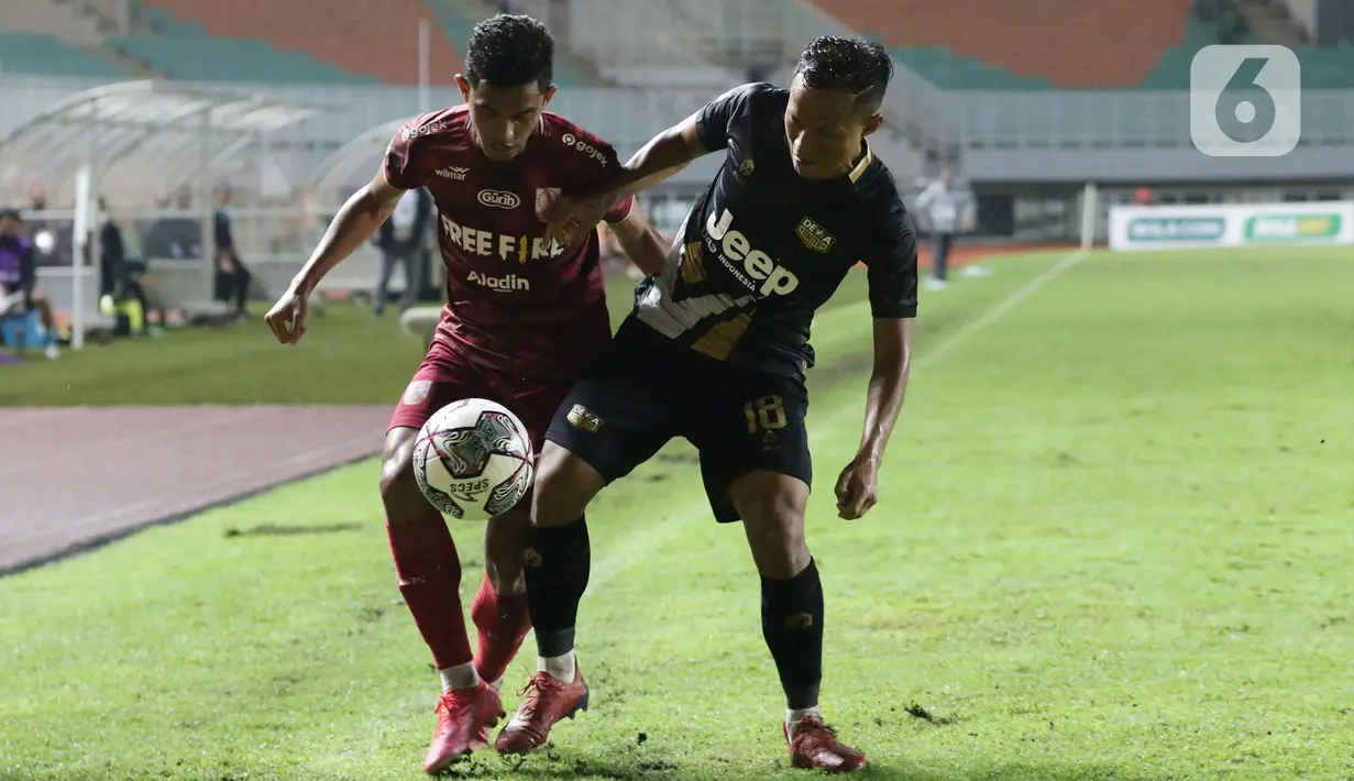 Pemain Martapura Dewa United, Jajang Sukmara (kanan) berebut bola dengan pemain Persis Solo pada laga semifinal Liga 2 Indonesia 2021 di Stadion Pakansari, Bogor, Senin (27/12/2021). Persis Solo unggul 2-1 dan memastikan satu tempat promosi ke BRI Liga 1. (Liputan6.com/Helmi Fithriansyah)