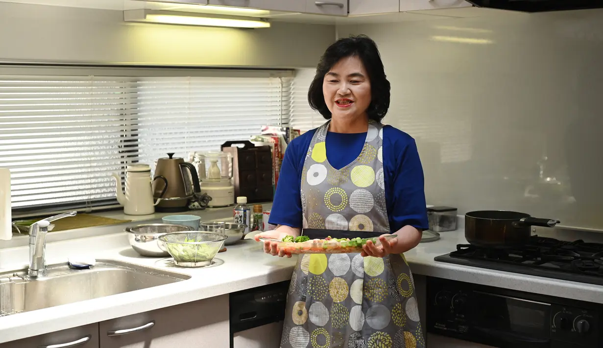 Pemenang kontes resep makanan Desa Olimpiade Tokyo 2020 Yoko Nishimura memegang hidangannya di Tokyo, Jepang, 12 Juli 2021. Desa Olimpiade Tokyo 2020 jadi kesempatan atlet untuk mencicipi masakan Jepang yang terkenal. (KAZUHIRO NOGI/AFP)