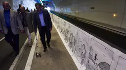 Direktur festival komik kota Lyon, mengatakan kartun hitam-putih melapisi dinding terowongan di kota sepanjang1.625 meter, Paris, Senin (23/5/2016). (AFP Photo/Jean Philippe)