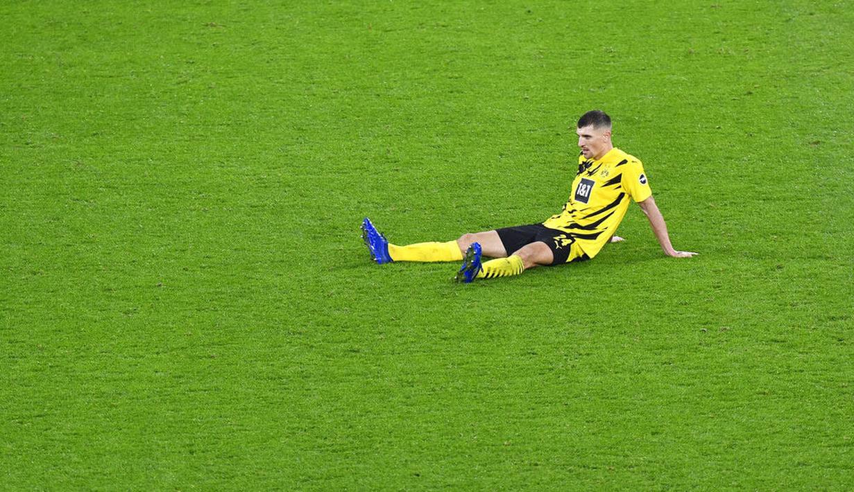 Pemain Borussia Dortmund, Thomas Meunier, terduduk lesu di lapangan usai ditaklukkan Bayern Munchen pada laga Bundesliga di Stadion Signal Iduna Park, Sabtu (7/11/2020). Bayern menang dengan skor 3-2. (AP Photo/Martin Meissner, Pool)
