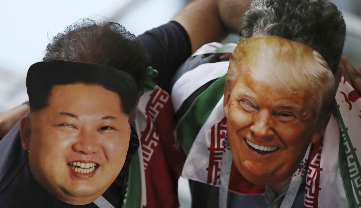 Suporter Iran memakai topeng wajah dari Donald Trump dan Kim Jong-un saat menonton laga grup B Piala Dunia melawan Spanyol di Kazan Arena, Kazan, Rabu (20/6/2018). Iran kalah 0-1 dari Spanyol. (AP/Eugene Hoshiko)
