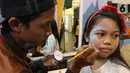Pengunjung sedang body painting pada wajah pada ICEFEST 2019 di BSD Tangerang, Kamis (19/12/2019). ICEFEST 2019 hadir mengangkat kisah persahabatan ILO dan Aiden di desa Happy Village yang diharap dapat memberikan edukasi yang dikemas dengan hiburan kepada anak-anak. (Liputan6.com/Fery Pradolo)