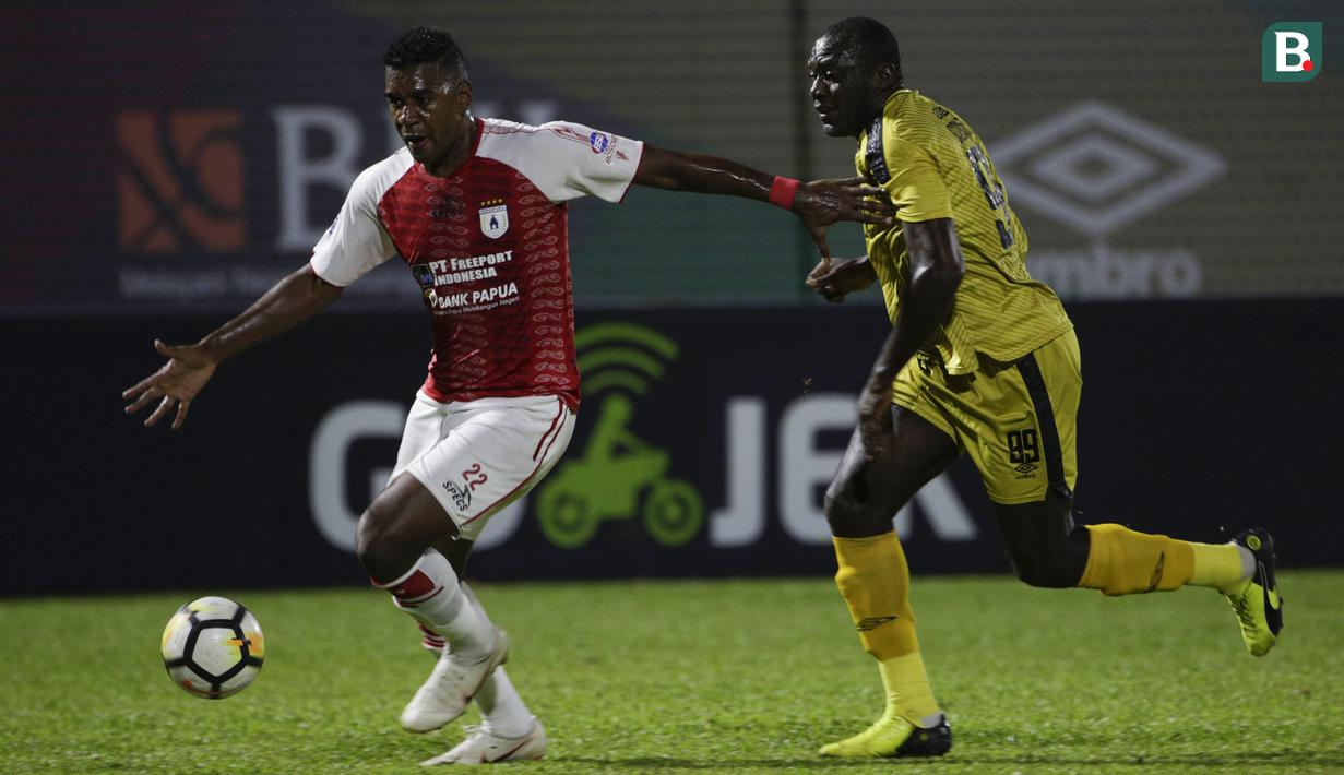 Bek Persipura, Marcio Rozario, menghindari striker Bhayangkara FC, Herman Dzumafo, pada laga Liga 1 Indonesia di Stadion PTIK, Jakarta, Senin (18/11). Bhayangkara menang 2-0 atas Persipura. (Bola.com/Vitalis Yogi Trisna)