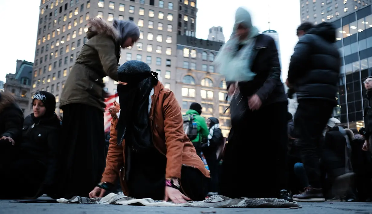 Sejumlah wanita muslim bergegas usai melakukan salat berjemaah sebelum melakukan aksi protes di Manhattan, New York (1/2). Mereka menentang kebijakan Presiden Donald Trump melarang warga tujuh negara Muslim masuk AS. (AFP/Spencer Platt)