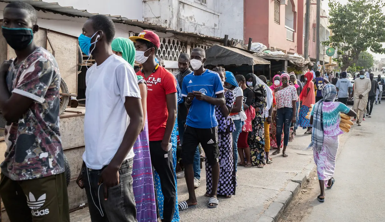Putri Bara Tambedou, Ndyeye Fatou (kanan tengah) antre untuk membeli roti pada bulan suci Ramadan, di Dakar, Senegal, 25 April 2020. Tahun ini, banyak keluarga menjalankan Ramadan di rumah dengan larangan pertemuan publik dan jam malam untuk menekan penyebaran Covid-19. (AP/Sylvain Cherkaoui)