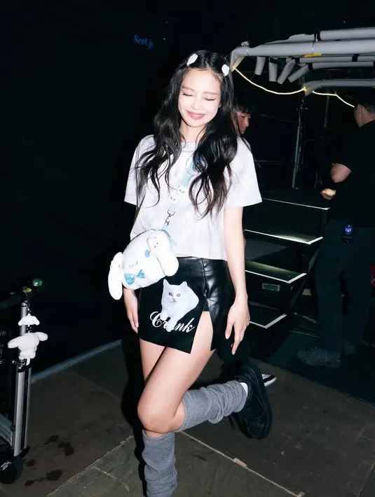 Jennie BLACKPINK semakin manis dengan tampilan minimalis. Rok hitam dari kulit yang dikenakannya memiliki detail slit dan ia padukan dengan kaus kaki panjang berwarna abu-abu, serta alas kaki hitam.