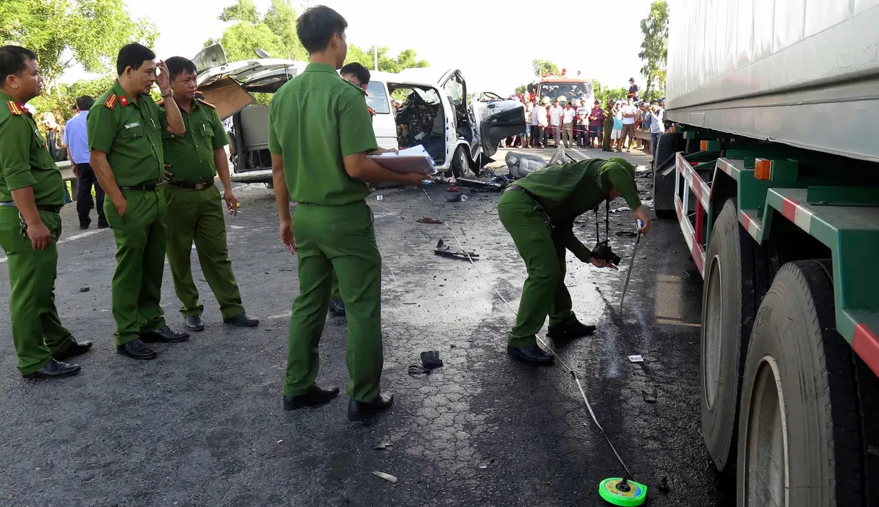 Petugas memeriksa lokasi kecelakaan sebuah van yang membawa rombongan pengantin dengan truk kontainer di Quang Nam, Vietnam, Senin (30/7). 14 orang dalam satu keluarga termasuk pengantin pria tewas seketika. (Do Van Truong/Vietnam News Agency via AP)