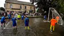 Tiang gawang dipasang di sungai dan pemain berusaha mencetak gol sebanyak mungkin, sambil membuat semua penonton basah kuyup dalam prosesnya. (AP Photo/Frank Augstein)