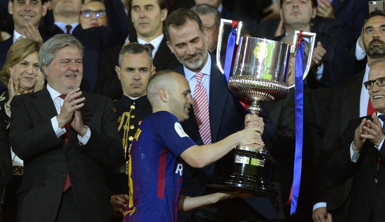 Gelandang Barcelona, Andres Iniesta, menerima trofi Piala Raja Spanyol di Stadion Wanda Metropolitano, Madrid, Sabtu (21/4/2018). Sebanyak enam gelar Piala Raja Spanyol diraihnya bersama La Blaugrana. (AFP/Cristina Quicler)