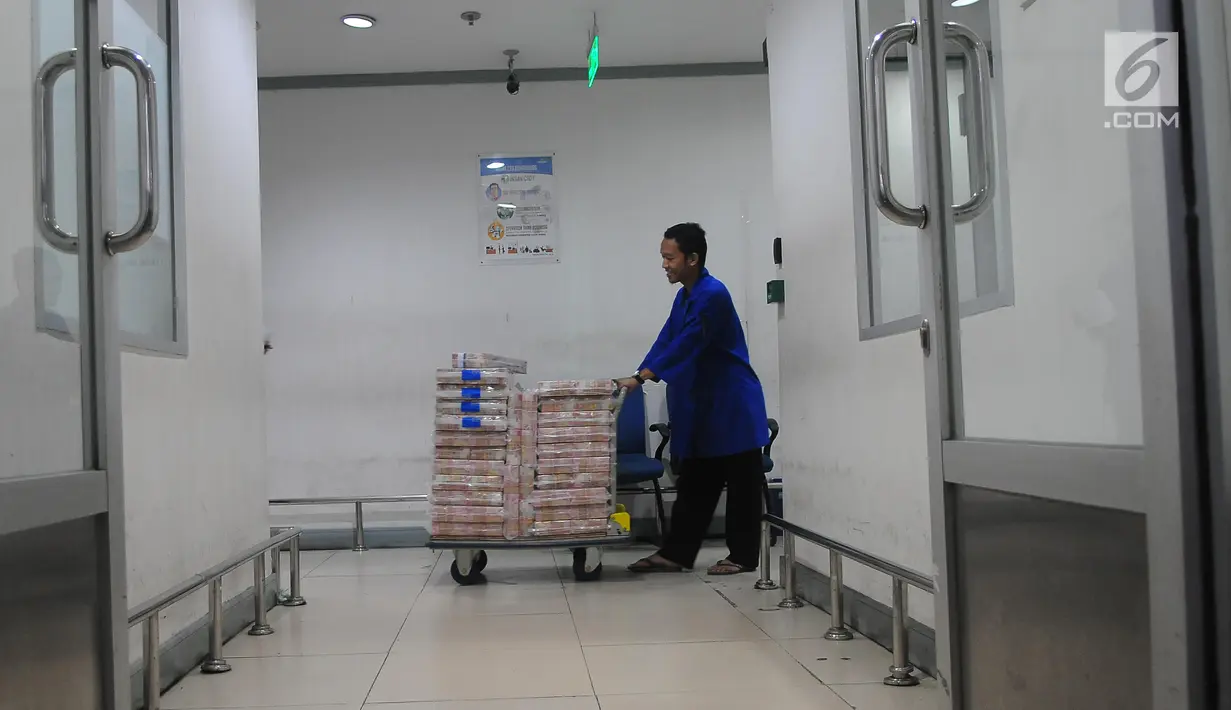 Karyawan mendorong troli berisi uang di Cash Pooling Bank Mandiri, Jakarta, Kamis (9/5/2019). Sebesar 18 persen dari dana tunai sebesar Rp 54,9 triliun yang disiapkan oleh Bank Mandiri saat Ramadan dan jelang Idul Fitri 2019 akan ditempatkan di kantor cabang. (Liputan6.com/Angga Yuniar)