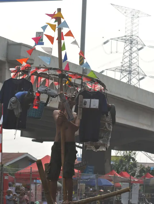 Dalam lomba titian bambu para peserta harus dapat menjaga keseimbangannya di atas bilah batang bambu setinggi 5 meter yang dibentangkan di atas aliran Kalimalang. (merdeka.com/Imam Buhori)