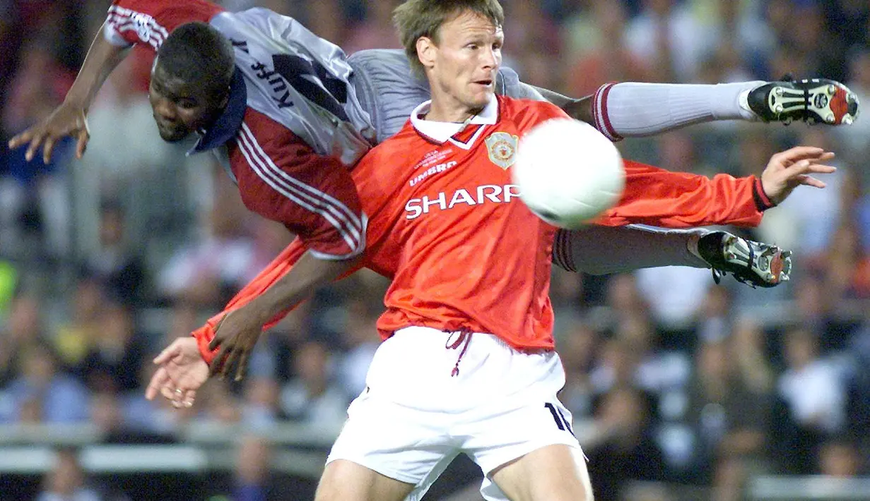 Striker Manchester United, Teddy Sheringham, berebut bola dengan bek Bayern Munchen, Samuel Osei Kuffour, pada laga final Liga Champions di Stadion Camp Nou, Barcelona (26/5/1999). Manchester United menang 2-1 atas Bayern Munchen. (AFP/Eric Cabanis)