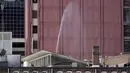 Jendela-jendela pecah dan pipa air yang rusak menyemprot di sebuah gedung dekat lokasi ledakan di pusat kota Nashville, Tennessee, Amerika Serikat, Jumat (25/12/2020). Tim khusus telah diterjunkan untuk melakukan investigasi di lokasi ledakan. (AP Photo/Mark Humphrey)