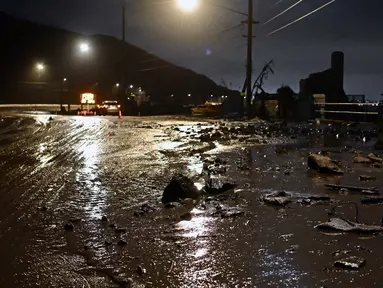 Lumpur dan bebatuan menutupi Pacific Coast Highway, dekat zona Kebakaran Palisades, selama badai di Malibu, California, pada tanggal 13 Februari 2025. (AGUSTIN PAULLIER/AFP)