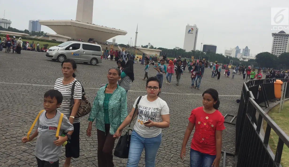Sejumlah pengunjung menikmati suasana kawasan Silang Monumen Nasional (Monas), Jakarta, Sabtu (30/12). Monumen setinggi 132 meter tersebut tak pernah sepi dari pengunjung, apalagi bila menjelang tahun baru. (Liputan6.com/Immanuel Antonius)