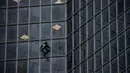 Pendaki Alain Robert atau French Spiderman memanjat Menara Total di kawasan bisnis La Defense, Paris, Prancis, Senin (13/1/2020). Alain memanjat gedung 48 lantai tersebut sebagai dukungan untuk pekerja yang mogok karena menentang reformasi pensiun di Prancis. (Thomas SAMSON/AFP)