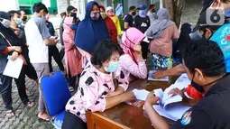 Warga antre menerima Bantuan Sosial Tunai (BST) di Kelurahan Pondok Benda, Kecamatan Pamulang, Tangerang Selatan, Minggu (10/01/2021). Sebanyak 92.737 kepala keluarga tercatat sebagai penerima BST di wilayah Tangerang Selatan senilai Rp300 ribu. (Liputan6.com/Fery Pradolo)