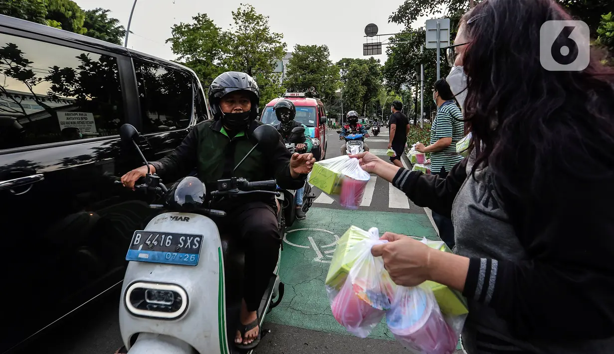 Jemaat membagikan takjil kepada masyarakat menjelang buka puasa di Gereja GPIB Effatha, Jakarta, Rabu (20/4/2022). Momen menjelang buka puasa Ramadhan digunakan jemaat GPIB Effatha berbagi takjil gratis untuk kaum Muslimin di Jalan Melawai, tepatnya di depan gereja itu. (Liputan6.com/Johan Tallo)