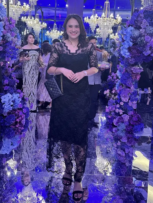Melati Daeva Oktavianti elegan mengenakan dress brokat hitam lengan panjang. Serasi dengan warna clutch Chanel dan heelsnya. Rambutnya dibiarkan terurai. @melatidaeva.