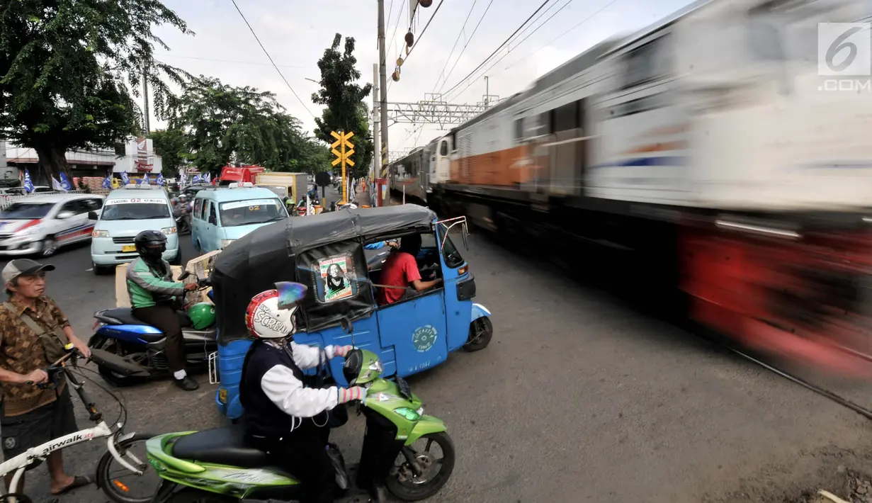 Sejumlah kendaraan berhenti di perlintasan kereta api Nomor 52 di Pisangan Lama, Jakarta, Kamis (11/4). Pintu perlintasan ini dan JPL 66 di Jalan Stasiun Cakung, Jaktim, akan ditutup permanen saat diberlakukannya Double Double Track (DDT) lintas Manggarai-Cikarang. (merdeka.com/Iqbal S. Nugroho)