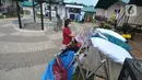 Seorang perempuan menjemur pakaian di luar Rumah Lawan COVID-19 (RLC) Serpong, Tangerang Selatan, Banten, Rabu (2/6/2021). RLC merawat lebih dari 60 pasien positif covid-19 yang melonjak drastis lebih dari 50 persen pasca lebaran. (merdeka.com/Arie Basuki)