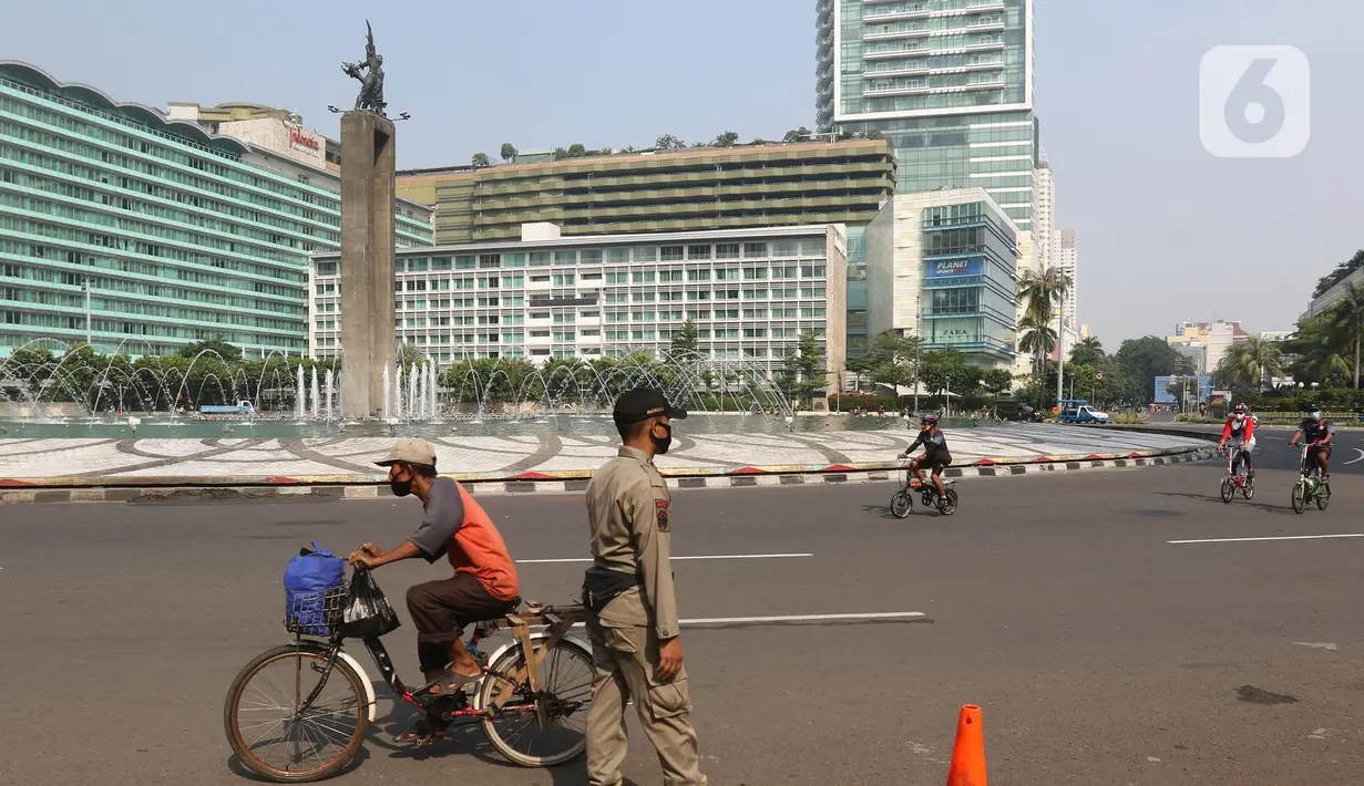 Petugas Satpol PP berjaga saat CFD di Bunderan HI Jakarta, Minggu (7/6/2020). Sesuai Peraturan Gubernur (Pergub) DKI Jakarta nomor 51 tahun 2020 tentang Pelaksanaan PSBB Pada Masa Transisi, pembukaan kegiatan sosial budaya dilakukan secara bertahap.   (Liputan6.com/Herman Zakharia)