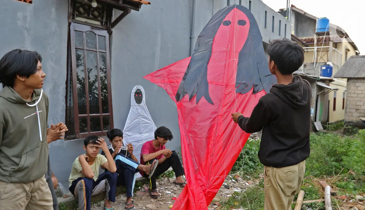 Layangan berbentuk pocong dan kuntilanak yang selesai dibuat di kawasan Gandaria, Depok, Jawa Barat, Selasa (30/06/2020). Ditengah pandemi COVID-19, anak - anak di kawasan Gandaria Depok mengisi waktu luang dengan membuat layang-layang dengan beragam bentuk. (Liputan6.com/Herman Zakharia)
