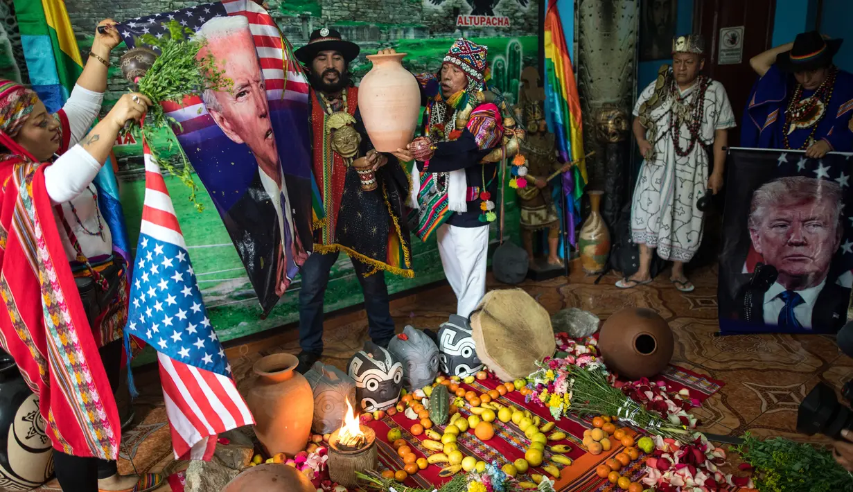 Dukun melakukan ritual mistik dengan memegang gambar calon presiden dari Partai Demokrat Joe Biden dan pesaingnya Donald Trump, di Lima, Peru, Rabu (16/9/2020). Mereka mencoba memprediksi siapa pemenang dari pemilihan presiden AS yang akan dihelat pada 3 November mendatang. (AP Photo/Rodrigo Abd)