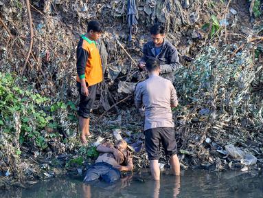 Polisi dan warga mengamankan terduga pelaku pelecehan seksual yang menceburkan diri di Kali Ciliwung, Manggarai, Jakarta, Minggu (7/6/2019). Pelaku dikejar massa usai melakukan pelecehan dengan modus mencegat korban perempuan mendapat hadiah dari sayembara televisi. (Liputan6.com/Fery Pradolo)