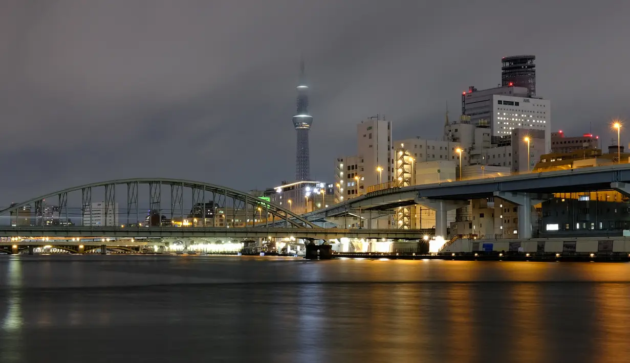 Tokyo Skytree (tengah) terlihat dengan sebagian besar lampu dimatikan sebagai bagian dari langkah-langkah penghematan energi menyusul peringatan pasokan listrik pemerintah untuk ibukota dan daerah sekitarnya, di Tokyo, Jepang pada Selasa (22/3/2022). (Philip FONG/AFP)