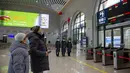 Para penumpang melihat informasi kereta di Stasiun Huanxian, yang berada di sepanjang jalur kereta yang menghubungkan Yinchuan dan Xi'an, di Wilayah Huanxian, Provinsi Gansu, China barat laut (26/12/2020). (Xinhua/Zhang Yongxin)