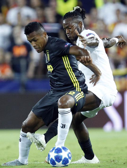 Bek Juventus, Alex Sandro, berebut bola dengan striker Valencia, Michy Batshuayi, pada laga Liga Champions di Stadion Mestalla, Valencia, Rabu (19/9/2018). Juventus menang 2-0 atas Valencia. (AP/Alberto Saiz)