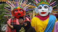 Pengunjung melakukan selfi didepan pajangan ondel-ondel dalam rangka Lebaran Betawi di Lapangan Banteng, Jakarta (22/08/15). Acara ini akan berlangsung pada tanggal 22-23 Agustus. (Liputan6.com/Gempur M Surya)