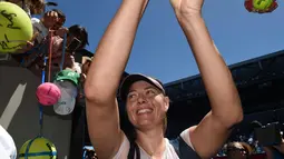 Maria Sharapova tersenyum saat memberi tanda tangan usai pertandingan melawan Tatjana Maria pada putaran pertama di kejuaraan tenis Australia Terbuka 2018 di Melbourne (16/1). Sharapova menang 6-1, 6-4. (AFP Photo / Greg Wood)