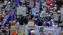 Ribuan buruh beratribut berwarna biru dan membawa spanduk terlihat berjalan memasuki Bundaran HI, Jakarta, Rabu (10/12/2014). (Liputan6.com/Faizal Fanani) 