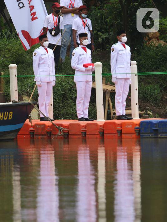 Anggota Paskibraka bersiap mengibarkan bendera merah putih di Sungai Cisadane, Kota Tangerang, Banten, Kamis (28/10/2021). Pengibaran bendera merah putih yang di ikuti puluhan pemuda tersebut di lakukan untuk memperingati hari sumpah pemuda. (Liputan6.com/Angga Yuniar)