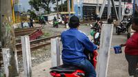 Kendaraan roda dua tetap melintas walaupun sudah ditutup di perlintasan kereta api di kawasan Tanah Abang-Palmerah Jakarta, Jumat (24/6/2022). PT Kereta Api Indonesia (Persero) atau KAI Daop 1 Jakarta menutup enam perlintasan liar sebagai upaya mewujudkan keselamatan dan keamanan perjalanan KA serta masyarakat.  (Liputan6.com/Faizal Fanani)