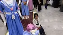 Seorang gadis Yaman duduk dengan pakaian barunya di ruang pamer membagikan pakaian kepada anak-anak yang kehilangan orang tua dalam konflik, sebagai bagian dari kegiatan amal selama bulan suci Ramadhan, di ibu kota Sanaa (8/4/2022). (AFP/Mohammed Huwais)