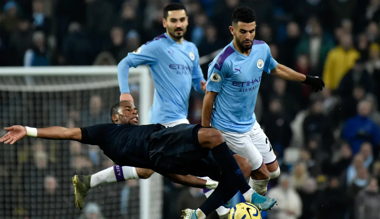 Pemain Manchester City Riyad Mahrez (kanan) berebut bola dengan pemainEverton Djibril Sidibe pada pertandingan lanjutan Liga Inggris di Etihad Stadium, Manchester, Inggris, Rabu (1/1/2020). Dua gol Gabriel Jesus membawa Manchester City menang 2-1. (AP Photo/Rui Vieira)