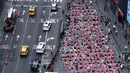 Orang-orang mengikuti acara yoga tahunan untuk merayakan Summer Solstice di Times Square, New York City, Rabu (21/6/2023). (Photo by TIMOTHY A. CLARY / AFP)