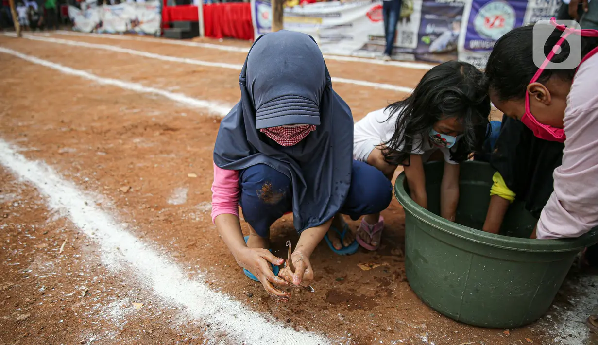 Anak-anak mengikuti lomba menangkap belut dengan menerapkan protokol Kesehatan di kawasan Pondok Cabe IV, Tangerang Selatan, Senin (17/8/2020). Lomba tersebut digelar untuk menyemarakkan HUT ke-75 Kemerdekaan Republik Indonesia. (merdeka.com/Faizal Fanani)