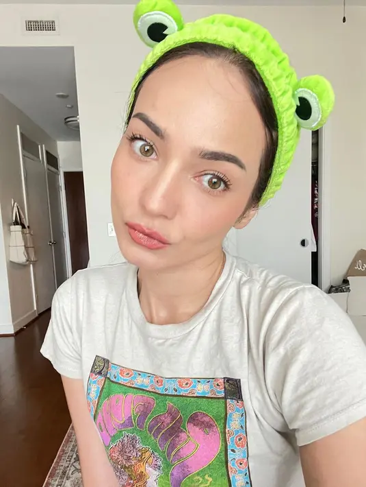 Selfie menawan dengan baju rumah, Enzy Storia tampilkan paras cantiknya. Mengenakan kaus santai, Enzy berfoto selfie mengenakan bando kodok hijau yang menggemaskan. [Foto: Instagram/enzystoria]