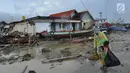 Warga membawa perkakas dari bangunan rumahnya yang rusak akibat terjangan tsunami di Kampung Sumur Pesisir, Pandeglang, Banten, Senin (24/12). Pascatsunami Selat Sunda, warga mulai kembali ke rumahnya masing-masing. (Merdeka.com/Arie Basuki)