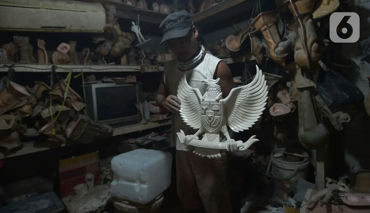 Perajin menyelesaikan kerajinan lambang Garuda Pancasila di bengkel rumahan, Jakarta, (13/8/2020). Menko bidang Perekonomian Airlangga Hartanto memaparkan anggaran Pemulihan Ekonomi Nasional (PEN) dalam bentuk bantuan bagi UMKM tercatat Rp32,5 triliun per 3 Agustus 2020. (merdeka.com/Imam Buhori)